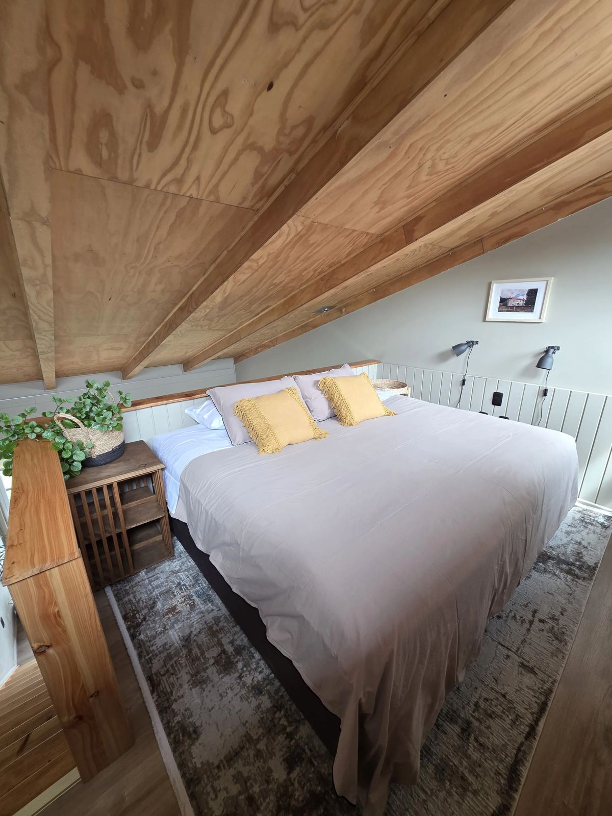 Dormitorio en el altillo bajo techo de madera